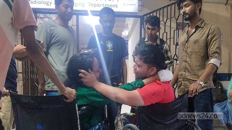 Overcome with grief, Ashiqul Islam breaks down in tears beside an injured relative in a wheelchair at Cox’s Bazar Sadar Hospital. Of the nine family members who went on holiday together, he fears he has lost six relatives from his in-laws’ family, including his wife. Photo: Sourav Dev