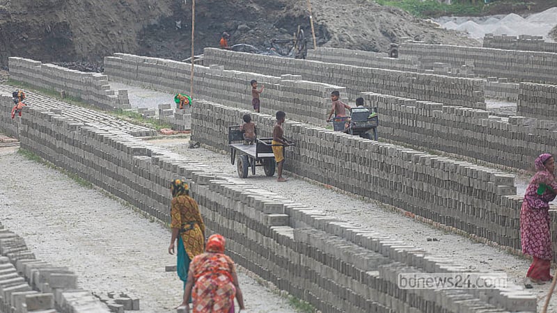 With work temporarily slack, children turn the rows of drying bricks into a playground at a kiln.  Photo: Abdullah Al Momin