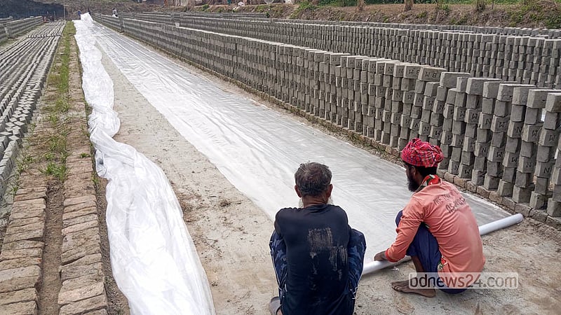Plastic sheets are kept ready to protect freshly moulded bricks from rain.  Photo: Abdullah Al Momin