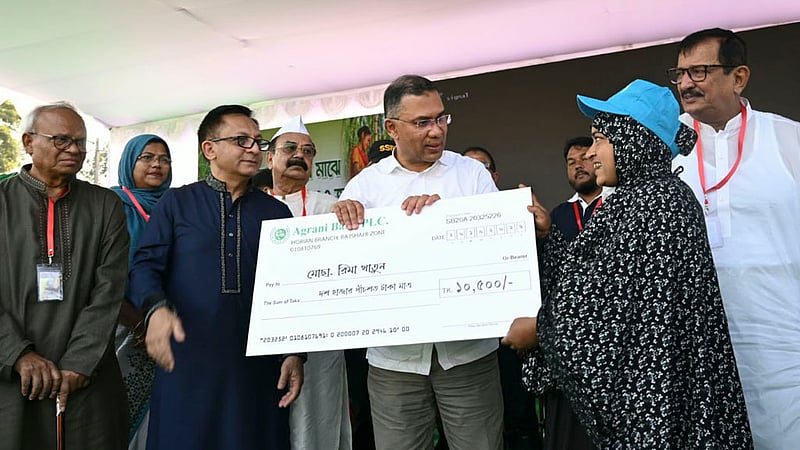 Prime Minister Tarique Rahman hands financial assistance to marginal sugarcane farmer Rima Khatun at a rally at Haji Muhammad Mohsin Government High School in Rajshahi on Tuesday, Oct 20, 2026. Photo: PMO