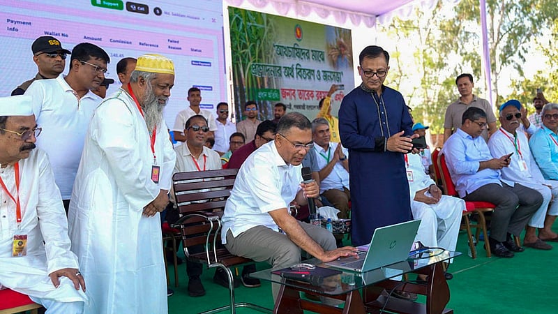 Prime Minister Tarique Rahman uses a computer to transfer financial assistance directly to sugarcane farmers’ bank accounts at a rally at Haji Muhammad Mohsin Government High School in Rajshahi on Tuesday, Oct 20, 2026. Photo: PMO
