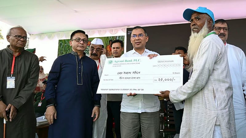 Prime Minister Tarique Rahman hands financial assistance to marginal sugarcane farmer Imajuddin at a rally at Haji Muhammad Mohsin Government High School in Rajshahi on Tuesday, Oct 20, 2026. Photo: PMO