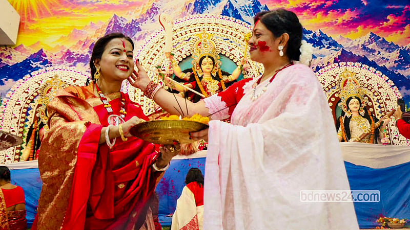 Married women smear vermilion on one another in the "Sindoor Khela" and play with coloured powder as drums, conch shells and ululation fill the Puja pavilion at Dhakeshwari National Temple before Goddess Durga is bid farewell on Bijoya Dashami. Photo: Shamsul Haque Ripon