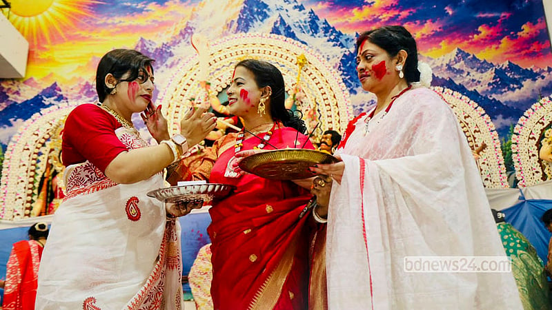 Married women smear vermilion on one another in the "Sindoor Khela" and play with coloured powder as drums, conch shells and ululation fill the Puja pavilion at Dhakeshwari National Temple before Goddess Durga is bid farewell on Bijoya Dashami. Photo: Shamsul Haque Ripon