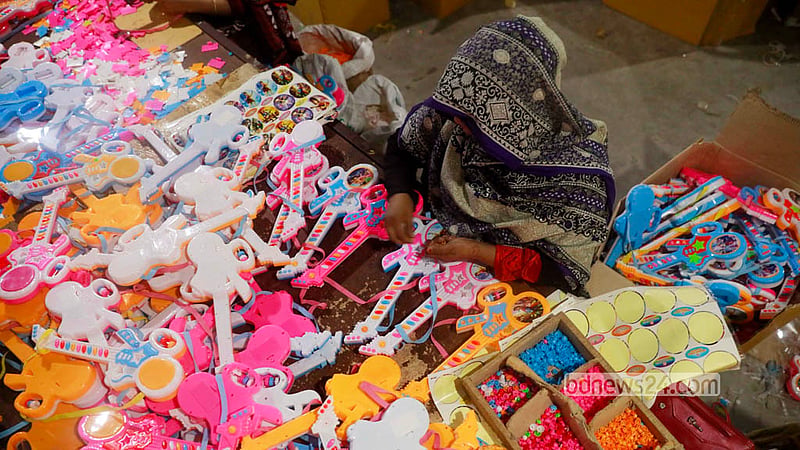 A female craftswoman decorates a plastic toy guitar at a toy factory in Dhaka’s Kamrangirchar. Photo: Shamsul Haque Ripon