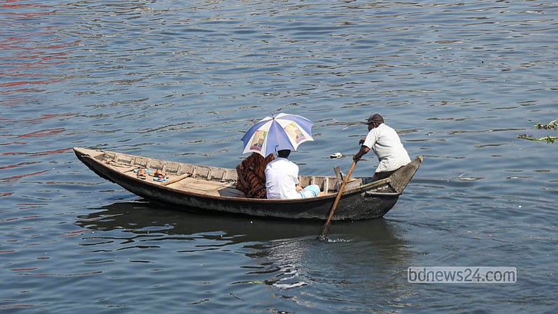 Passengers use umbrellas to find some relief from the heat while travelling by boat on the Buriganga River in Dhaka. Photo: Shamsul Haque Ripon