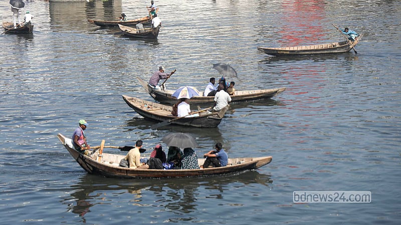 Passengers use umbrellas to find some relief from the heat while travelling by boat on the Buriganga River in Dhaka. Photo: Shamsul Haque Ripon