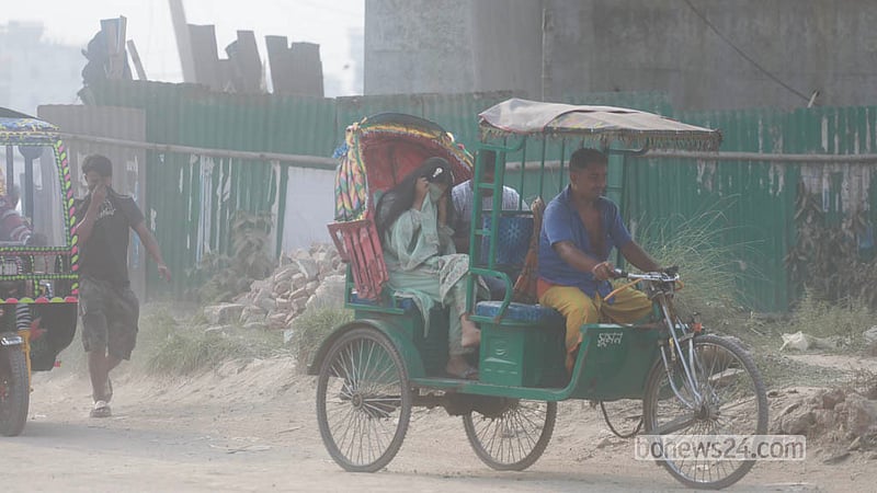 People travelling along the Babubazar-Gongtoli embankment road in Dhaka struggle through heavy dust pollution. Photo: Abdullah Al Momin