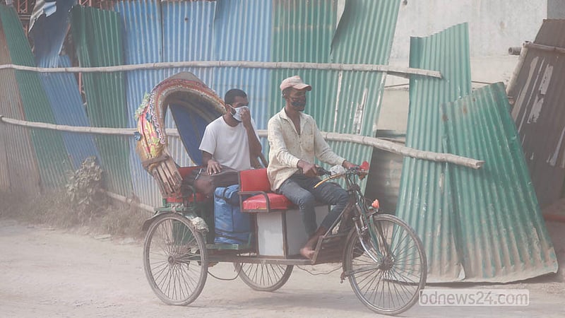Drivers and passengers wear protective masks to guard against air pollution. Doctors recommend using masks, warning that dust inhaled through the mouth and nose increases the risk of illness. Photo: Abdullah Al Momin