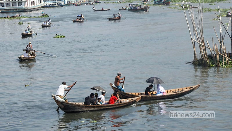 Passengers use umbrellas to find some relief from the heat while travelling by boat on the Buriganga River in Dhaka. Photo: Shamsul Haque Ripon