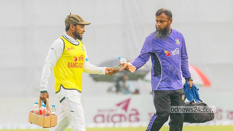 Mushfiqur Rahim walks onto the field carrying water and essential equipment for his teammates during the first day of the opening Test against West Indies in Mirpur. Photo: Shamsul Haque Ripon