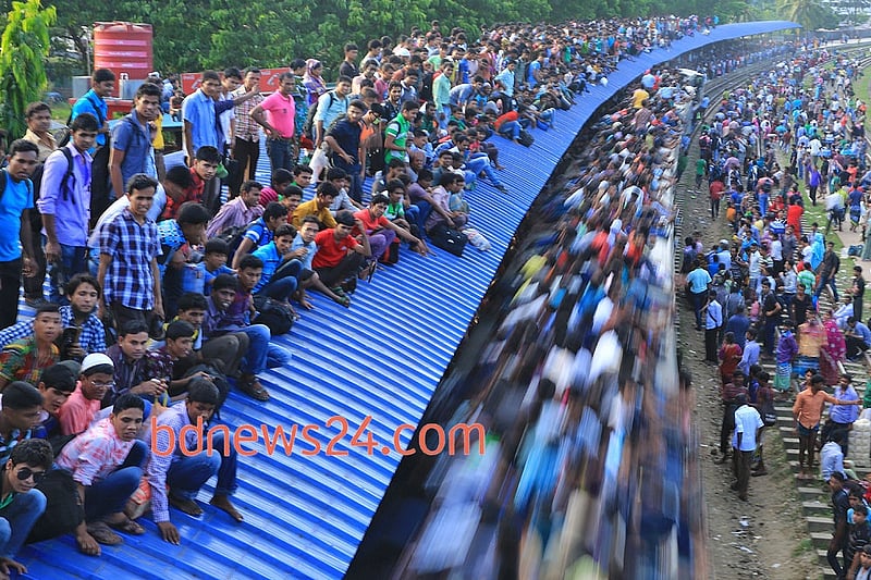 People ride on the rooftop of a train at Airport Railway station in Dhaka to reach their homes on Monday ahead of Eid-ul-Azha.