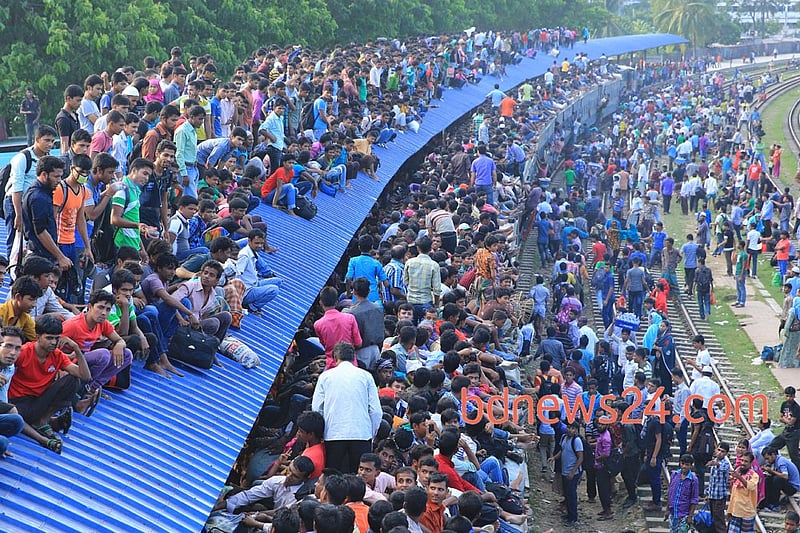 People ride on the rooftop of a train at Airport Railway station in Dhaka to reach their homes on Monday ahead of Eid-ul-Azha.