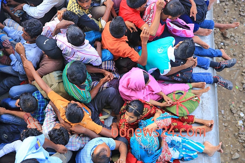People ride on the rooftop of a train at Airport Railway station in Dhaka to reach their homes on Monday ahead of Eid-ul-Azha.