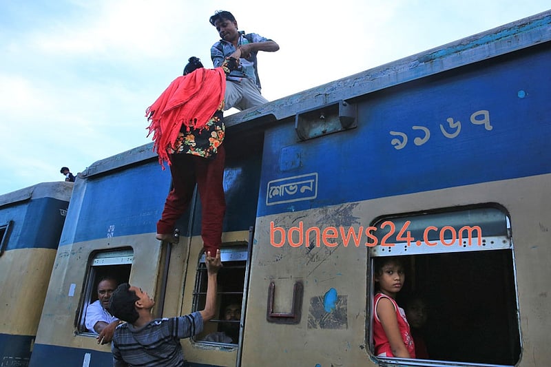 Desperate Eid-ul- Azha holiday makers mount the rooftop of a train to reach their destination at Airport Railway Station in Dhaka on Thursday.