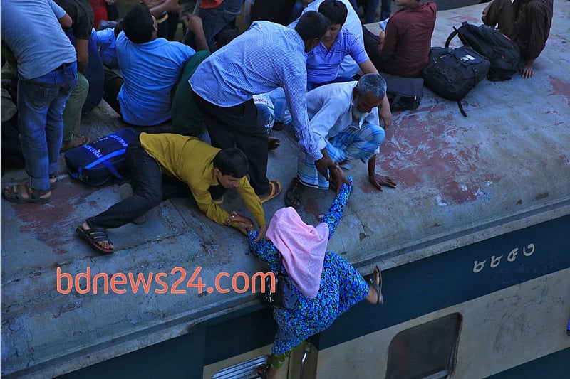 Desperate Eid-ul- Azha holiday makers mount the rooftop of a train to reach their destination at Airport Railway Station in Dhaka on Thursday.