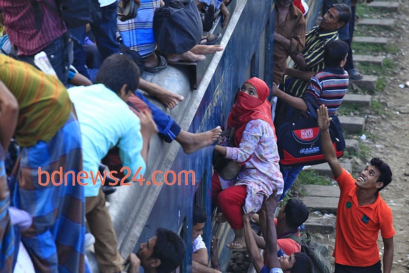Desperate Eid-ul- Azha holiday makers mount the rooftop of a train to reach their destination at Airport Railway Station in Dhaka on Thursday.