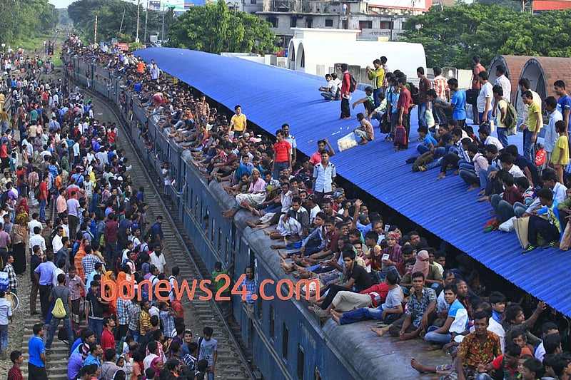 People ride on the rooftop of a train at Airport Railway station in Dhaka to reach their homes on Monday ahead of Eid-ul-Azha.
