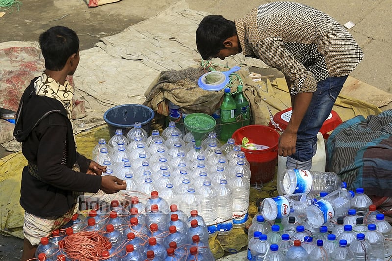 Used water bottles are being washed to refill water from washer line near Dhaka's Sadarghat area.