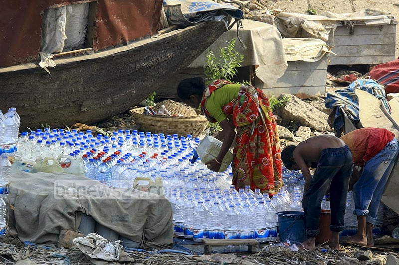 Used water bottles are filled with drinking water in a filthy environment on the banks of Buriganga at Dhaka's Sadarghat to be sold to launch passengers. One bottle of such water is sold for Tk 5 to 10.
