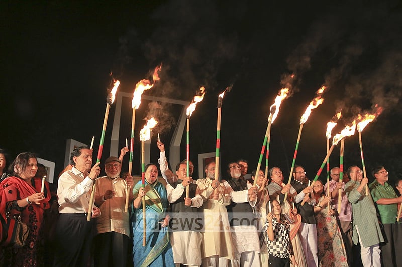 Ekattorer Ghatak-Dalal Nirmul Committee lights torches at Central Shaheed Minar in Dhaka on Wednesday night, demanding the observance of March 25 as `International Genocide Day'.