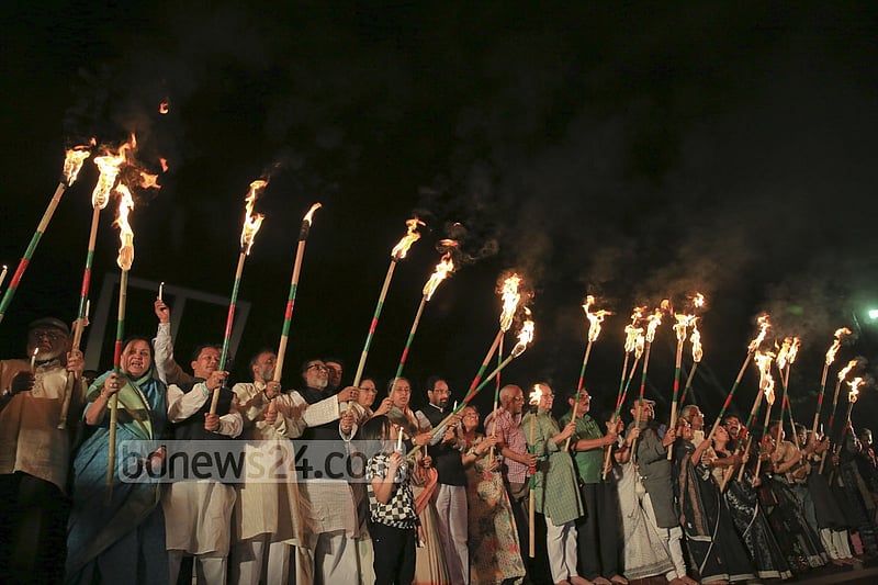 Ekattorer Ghatak-Dalal Nirmul Committee lights torches at Central Shaheed Minar in Dhaka on Wednesday night, demanding the observance of March 25 as `International Genocide Day'.