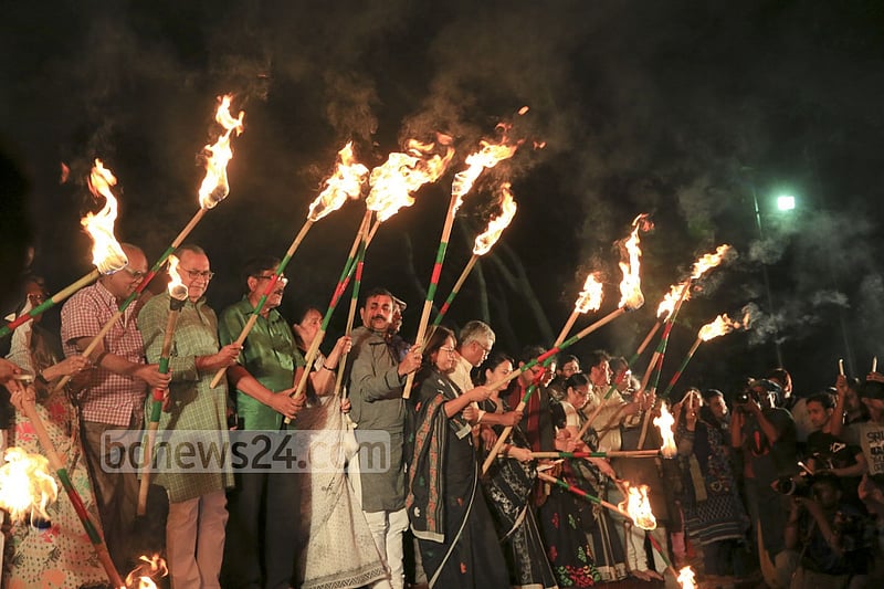 Ekattorer Ghatak-Dalal Nirmul Committee lights torches at Central Shaheed Minar in Dhaka on Wednesday night, demanding the observance of March 25 as `International Genocide Day'.