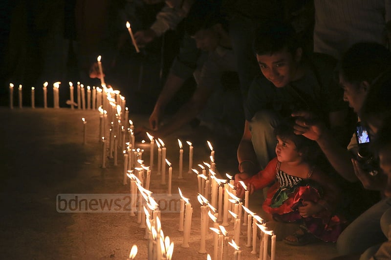 People light candles at the ‘Shaheed Bedi’ in memory of those killed by Pakistani army on the night of March 25, 1971, at Jagannath Hall on Tuesday.