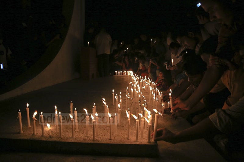 People light candles at the ‘Shaheed Bedi’ in memory of those killed by Pakistani army on the night of March 25, 1971, at Jagannath Hall on Tuesday.