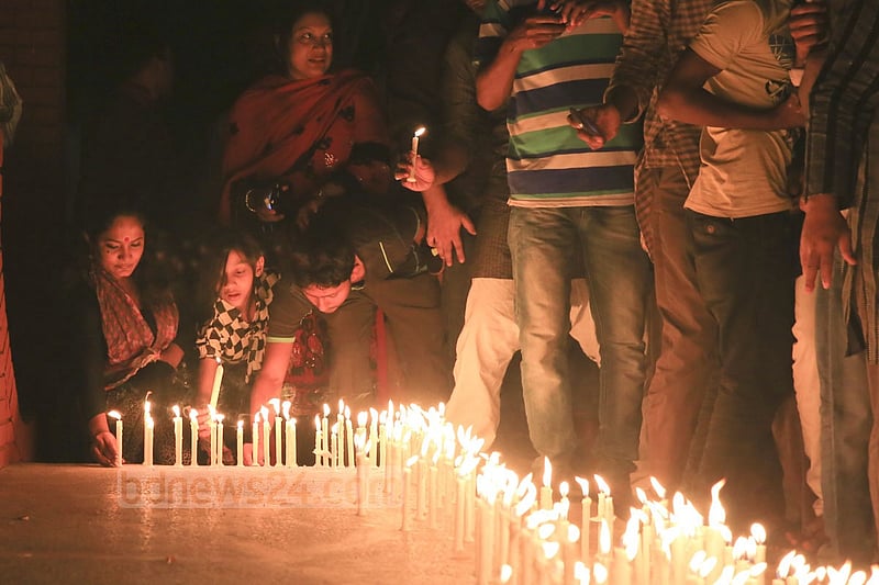 People light candles at the ‘Shaheed Bedi’ in memory of those killed by Pakistani army on the night of March 25, 1971, at Jagannath Hall on Tuesday.