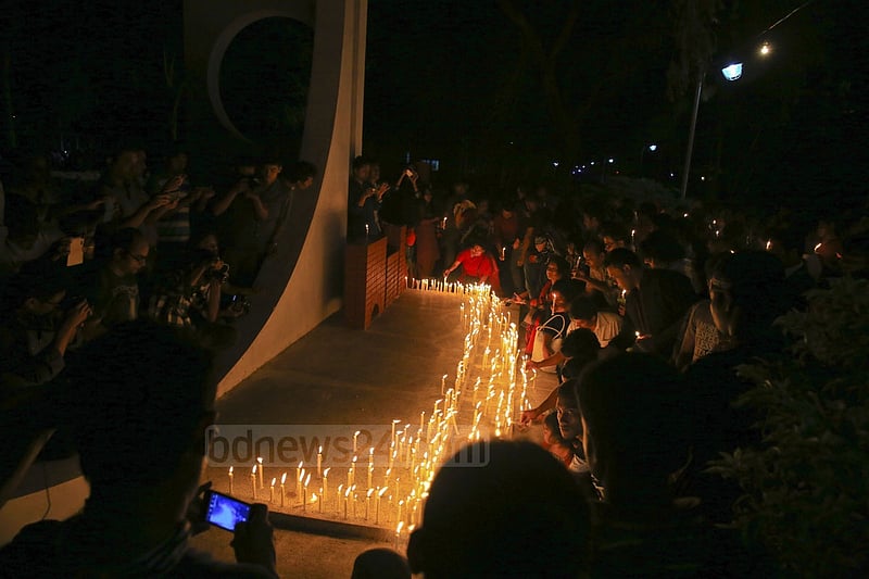 People light candles at the ‘Shaheed Bedi’ in memory of those killed by Pakistani army on the night of March 25, 1971, at Jagannath Hall on Tuesday.