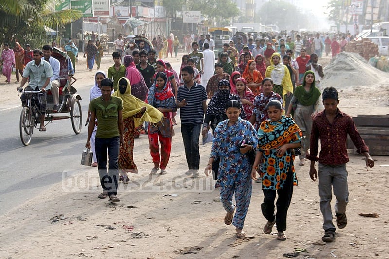 Garment workers walk to their workplaces. The wages earned from gruelling work are easily sent home using mobile banking.