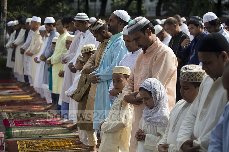 Several young boys pray alongside their guardians on Monday. Photo: mostafigur rahman
