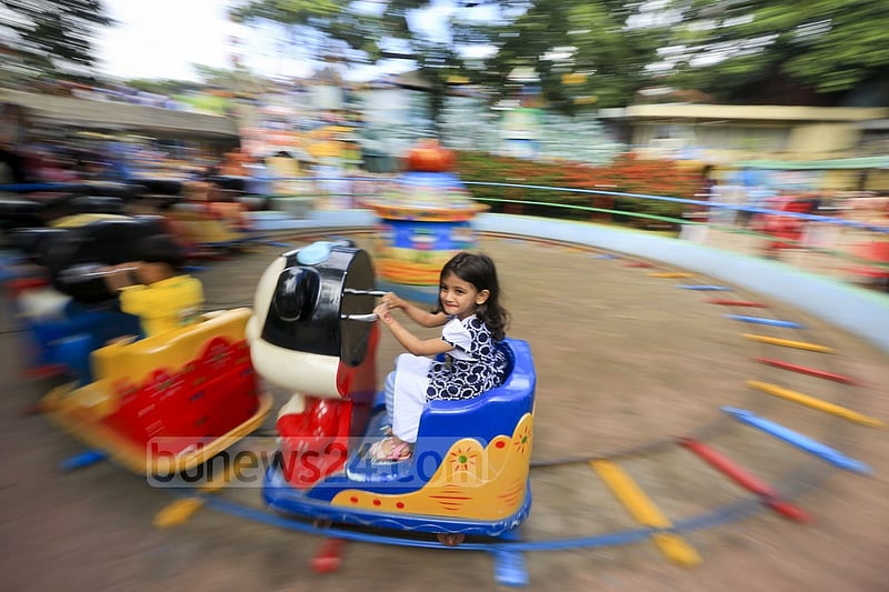 A child is all smiles as she takes a ride at DNCC Wonderland in Dhaka's Shyamoli a day after the Eid on Tuesday. Photo: asaduzzaman pramanik