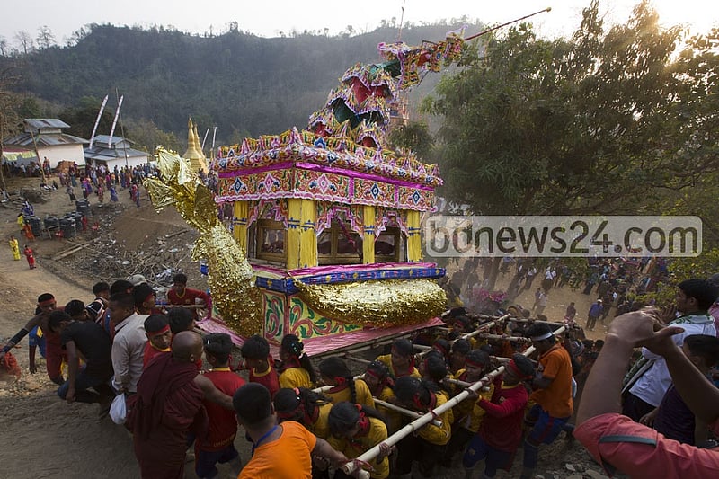 Young Marma men and and women carry the chariot-like tomb of Sasna Mahathero for the cremation.