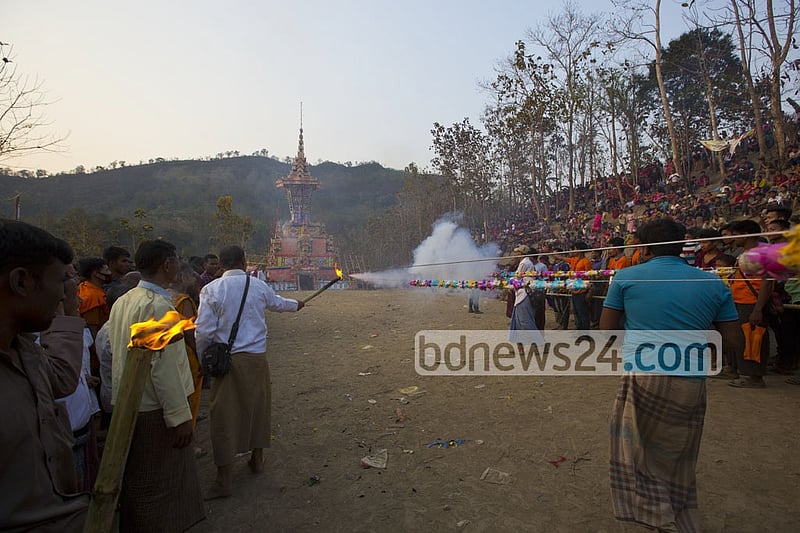 Buddhist monks and devotees light fireworks targeting the tomb until the fire for cremation starts.