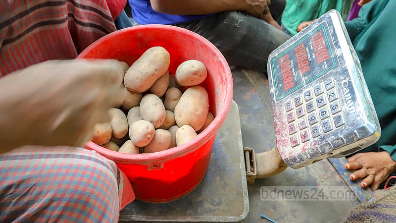 খুচরায় বিক্রির জন্য ট্রাকে আনা আলু মাপা হচ্ছে; একজন ক্রেতাকে দেওয়া হচ্ছে সর্বোচ্চ পাঁচ কেজি।