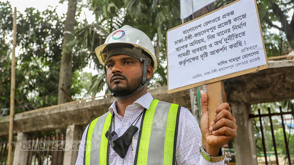 প্ল্যাকার্ড হাতে রেল প্রকল্পে ‘অনিয়মের’ প্রতিবাদ
