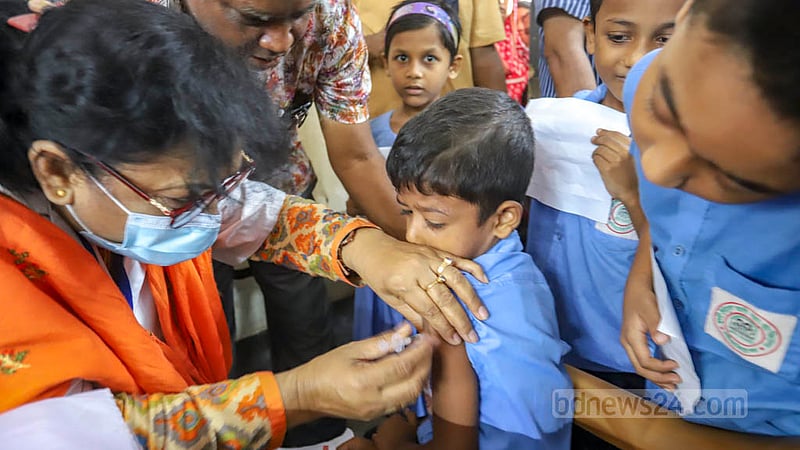 কাজীপাড়ায় হাজী ইউসুফ আলী সরকারি প্রাথমিক বিদ্যালয়ে বৃহস্পতিবার কোভিড টিকা নিচ্ছে এক শিশু। ঢাকার ২১টি স্কুল কেন্দ্রে ৫ থেকে ১১ বছর বয়সী শিশুদের এই টিকা দেওয়া হচ্ছে।
