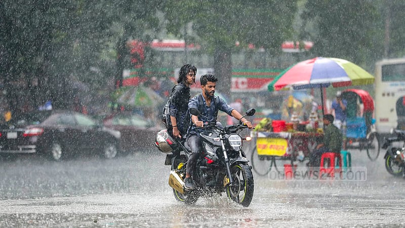 ঢাকা বিশ্ববিদ্যালয় এলাকায় সোমবার দুপুরে ভাদ্রের বৃষ্টি মাথায় এক মোটরসাইকেল চালক ও আরোহী। 