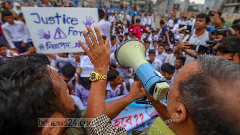 আন্দোলনরত শিক্ষার্থীদের সড়ক ছাড়তে হ্যান্ড মাইকে আহ্বান জানাচ্ছিলেণ সরকারি বিজ্ঞান স্কুলের শিক্ষক মোহাম্মদ শাহজাহান মিয়া; তবে তাতে সায় মেলেনি।