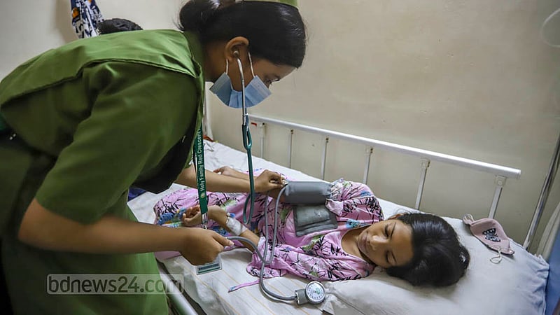 কুড়িলের ১১ বছর বয়সী তানজিকা রহমান ইতি তিন দিন ধরে ডেঙ্গু নিয়ে ঢাকার হলি ফ্যামিলি রেড ক্রিসেন্ট হাসপাতালে চিকিৎসা নিচ্ছেন। রোববার তাকে সেবা দিচ্ছেন এক স্বাস্থ্যকর্মী।