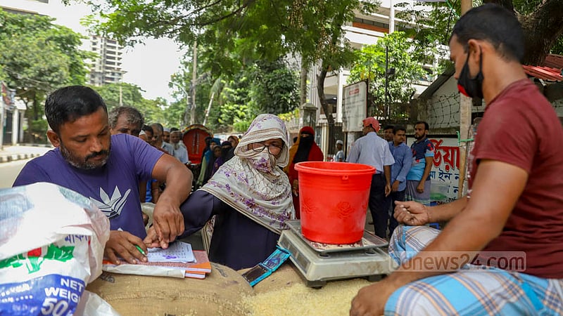 খাদ্য অধিদপ্তরের ওএমএসের ট্রাক থেকে চাল কেনার সময় নেওয়া হচ্ছে নাম এবং টিপ সই।