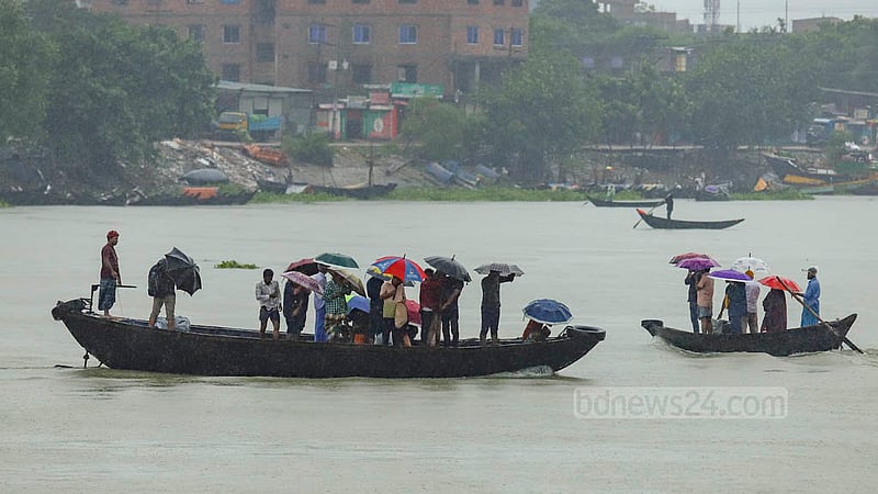 ঘূর্ণিঝড় সিত্রাংয়ের প্রভাবে বৃষ্টির মধ্যে সোমবার বুড়িগঙ্গা নদী নৌকা দিয়ে পার হচ্ছে মানুষ।