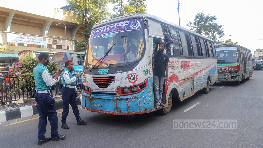 ঢাকার গুলিস্তানে শুক্রবার দুপুরে সড়ক আটকে যাত্রী তোলায় এক বাসকে আটকের চেষ্টায় ট্রাফিক পুলিশের দুই সদস্য।