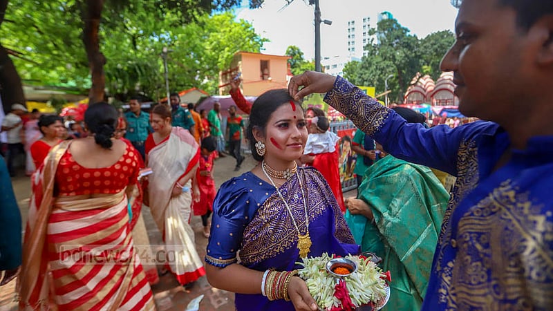 ঢাকেশ্বরী মন্দিরে বুধবার বিজয়া দশমীর সিঁদুর খেলায় স্ত্রীর সিঁথিতে সিঁদুর পরিয়ে দিচ্ছে স্বামী।