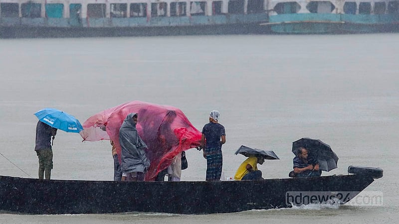 ঘূর্ণিঝড় সিত্রাংয়ের প্রভাবে সোমবার দিনভর বৃষ্টি হচ্ছে ঢাকায়। বৃষ্টি থেকে বাঁচতে কারও মাথায় পলিথিন, কারও মাথায় ছাতা, তারা নৌকায় পার হচ্ছেন বুড়িগঙ্গা নদী।