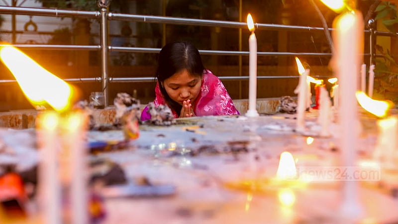 প্রবারণা পূর্ণিমায় ঢাকার বাসাবো বৌদ্ধ মন্দিরে প্রণামরত এক পুণ্যার্থী।