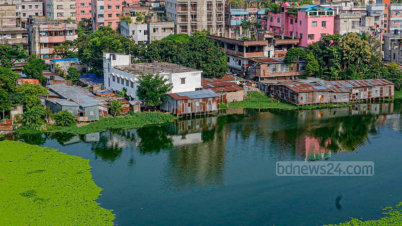 খিলগাঁও চৌধুরীপাড়া ঝিলের পাড় দখল করে পানির ওপর বানানো হয়েছে টিনশেড ঘর।