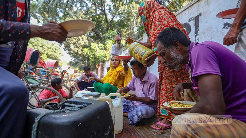ঢাকা বিশ্ববিদ্যালয় এলাকায় নিম্ন আয়ের মানুষের জন্য প্রতিদিন ফুটপাতের ওপর দুপুরের খাবার নিয়ে বসেন এক নারী।